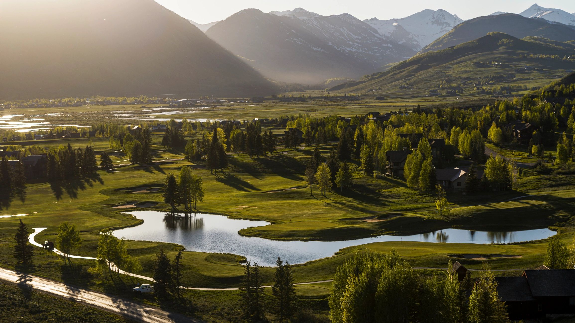 Aerial golf course landscape with mountain backdrop